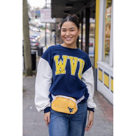 Model wearing the navy WVU women's crew sweatshirt with white sleeve, navy sleeve cuffs, and a gold and white WVU graphic on chest