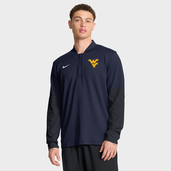 Male model wearing the navy Nike lightweight quarter zip pullover with the Flying WV Logo at left chest