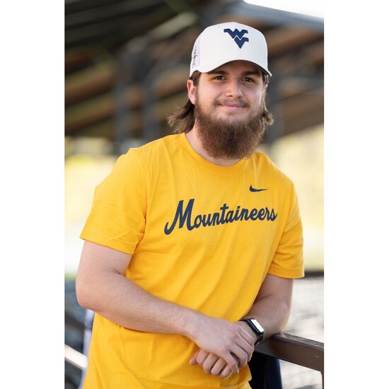 Model wearing the gold Nike WVU tee with Mountaineers diagonal script screenprint on the chest