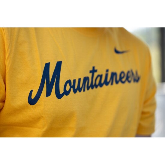 Close up of the Mountaineers diagonal script screenprint on the chest of the gold Nike WVU tee