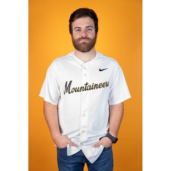 Model wearing the white Nike WVU baseball jersey with full chest ultrastitch heat applied sublimated twill Mountaineers verbiage