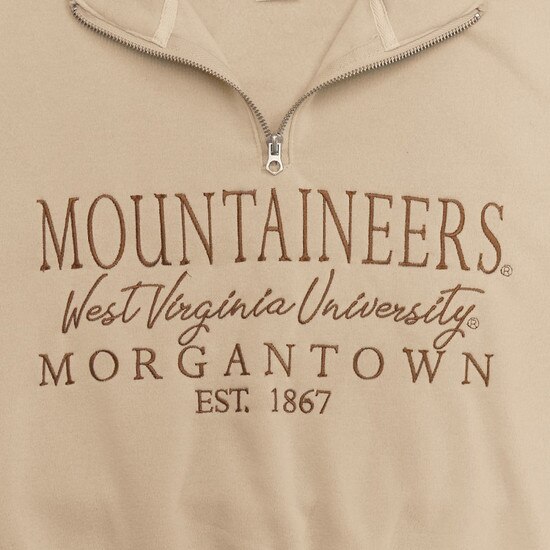 Close up of the Mountaineers over West Virginia University over Morgantown over EST. 1867 embroidered as front graphic on the sand WVU cropped quarter zip