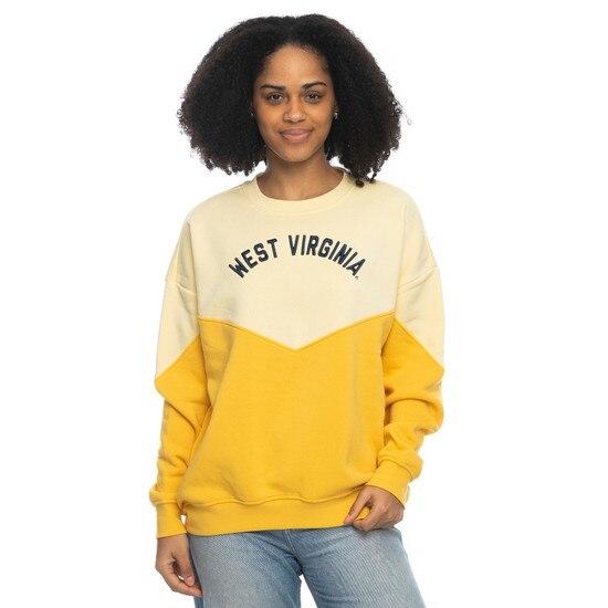 Model wearing the butter WVU women's crew with top of body and sleeves in butter, bottom of body and sleeves in gold, and arched raised embroidered West Virginia in navy as chest graphic